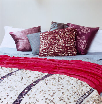 Red textured cushions on double bed