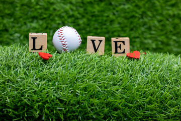 Baseball with word LOVE are on green grass