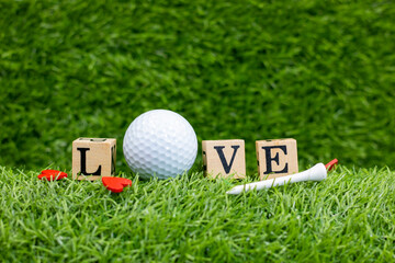 Golf ball with word LOVE are on green grass for Valentine's Day or Wedding