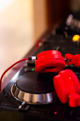 dj turntable and headphones. red headphones lying on dj controller. 