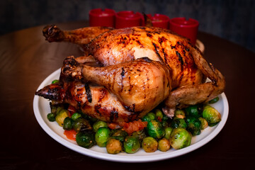 whole roasted chicken with brussels sprouts garnish. juicy roasted crispy skin chicken with vegetables. perfect roast whole chicken. whole grilled chicken with brussels sprouts. grill-roasted chicken