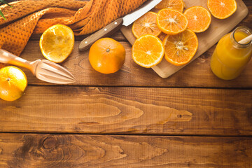 sliced oranges on a chopping board on a wooden table in the kitchen. Squeezing juice from oranges