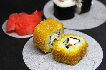 Hot Sushi rolls made of rice, smoked eel, cream cheese and flying fish roe - tobiko caviar