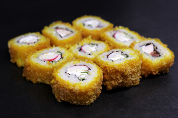 Hot Sushi rolls made of rice, smoked eel, cream cheese and flying fish roe - tobiko caviar