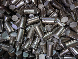 a pile of sawed stainless steel rod chunks - full frame close-up industrial background