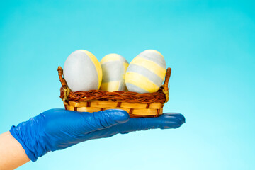 Easter in gloves. The family shares Easter eggs in protective gloves and a mask. Coronavirus,...