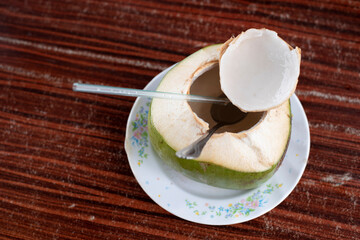Fresh coconut fruit drink on a table with drinking straw. Healthy food and lifestyle