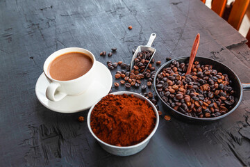.Roasted coffee beans with coffee powder and coffee cups.