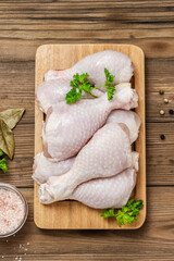 Raw chicken legs on wooden background. Top view, flat lay, space for text.