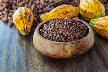 cocoa nibs and cocoa fruit on wooden table