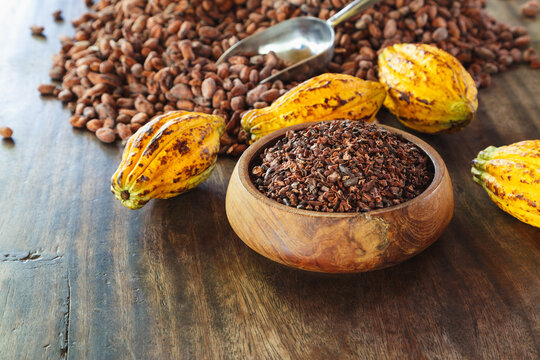 cocoa nibs and cocoa fruit on wooden table
