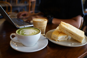 Toasted bread with kaya jam spread served with a cup of green tea latte and flat white latte, Malaysian cafe breakfast set.