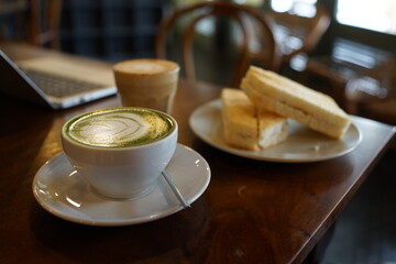 Toasted bread with kaya jam spread served with a cup of green tea latte and flat white latte, Malaysian cafe breakfast set.