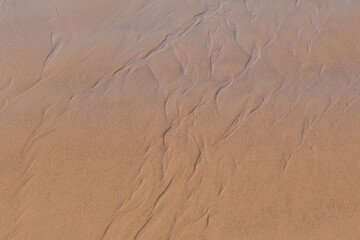 Extreme macro close up of fine beach sand surface pattern in the summer. Sandy trails, texture and background. Top view. Abstract Background. 