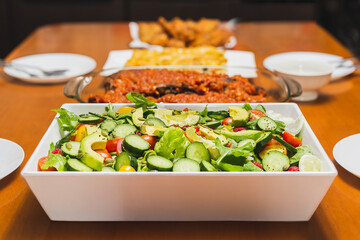 Set of vegetables on an white tray on a wooden table.