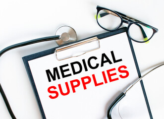 Text Medical Supplies in the folder with the stethoscope and glasses