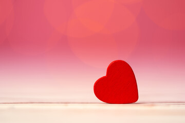Red heart decoration against pink bokeh background