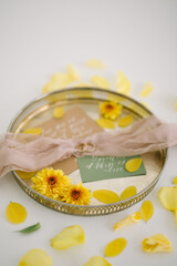 
wedding rings for the bride and groom on a tray with flowers, invitations and ribbons