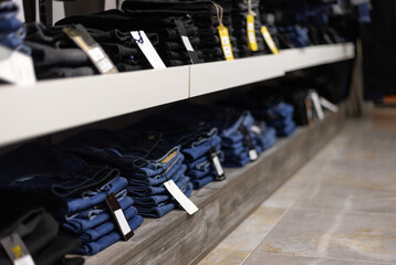 Stack of blue and black jeans in a shop. Concept of buy, sell, shopping and jeans fashion. Jeans texture closeup.