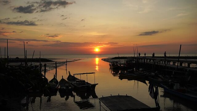 Beautiful sunset with silhouette of passerby at padang lalang coast, alor setar, kedah.