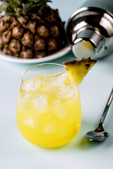 Glass of Cold and Tasty Pineapple Cocktail with Ice Cube Vertical Close Up