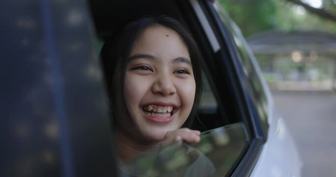 Cinematic Pretty Asian Girl In Car, Leans Out Passenger Side Car Window. Opens Window To Breathe Fresh Air Of Countryside.