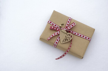 gift box tied with a red ribbon. carved wooden heart.