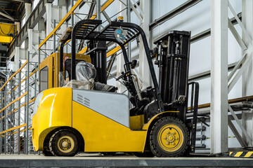Yellow forklift truck in a industrial warehouse building