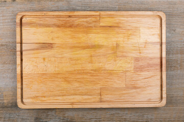 Empty cutting board on a wooden table. Space for text.