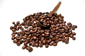 Coffee beans in wooden spoon. White background.