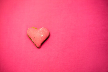 Heart-shaped biscuit. Pink background. Valentines day.