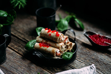 Pancakes with red caviar and salmon in a plate. Maslenitsa holiday