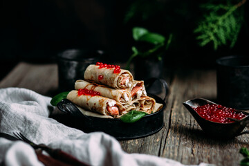 Pancakes with red caviar and salmon in a plate. Maslenitsa holiday