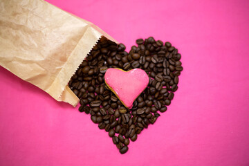 Coffee beans and sweet heart-shaped biscuit. Ecological paper package. Pink background.