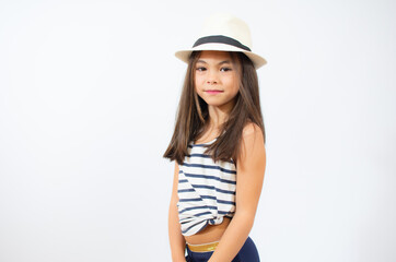Fototapeta premium Enjoying vacation. Little beauty in straw hat. Portrait of happy cheerful girl in summer hat over white background.