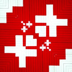 geometric shapes patterns and design from bright white plus sign on vivid red textured background