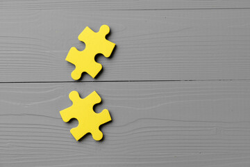 Yellow puzzle pieces on gray background close up