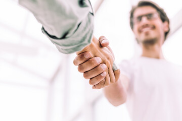 close up. young entrepreneur shaking hands with his business partner