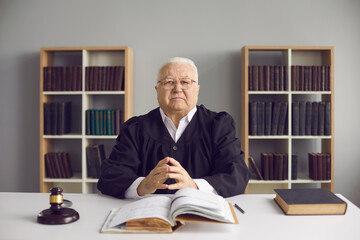 Man of law and justice. Honest wise mature male judge sitting at table in court. Portrait of...