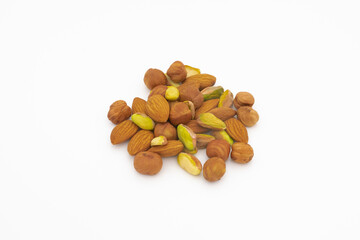 pile of pistachios almonds and hazelnuts, hazelnuts isolated on white background