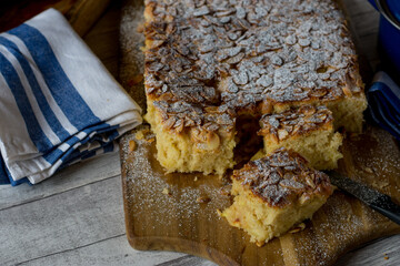 Almond cake with apples on a rustic wooden background