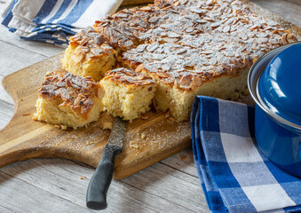 fresh baked apple cake with almonds on wooden board