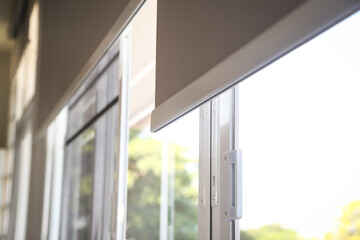 Details of white fabric roller blinds on the plastic window in the living room. 