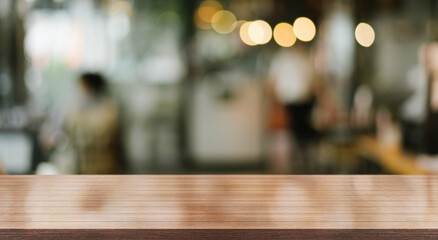 Empty wooden table top with lights bokeh on blur restaurant background.