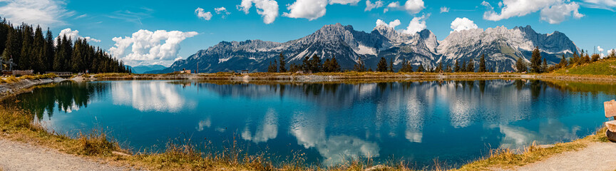 High resolution stitched panorama of a beautiful alpine summer view with reflections in a lake at the famous Astberg summit, Going, Wilder Kaiser, Tyrol, Austria - obrazy, fototapety, plakaty