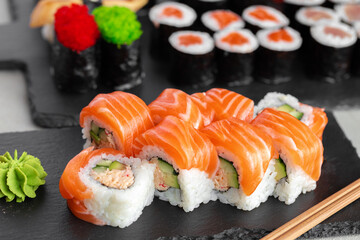 Sushi roll covered with fresh salmon served on plate