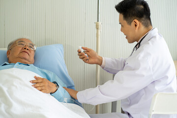 Asian medical doctor with old patient on the bed in hospital 