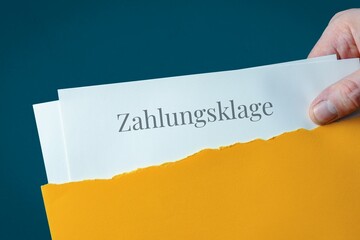 Zahlungsklage. Briefumschlag wird geöffnet. Hand entnimmt Unterlagen. Text auf Post-Brief.