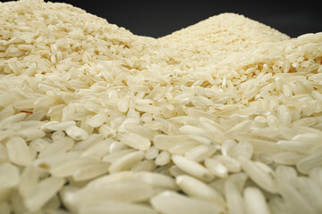 Uncooked dry rice grain on dark background macro