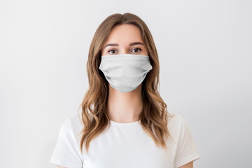 Close up portrait of a young girl wearing protective medical face mask isolated on a white background